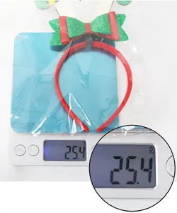 Christmas reindeer antler headband with festive bow shown on scale weighing 25.4g