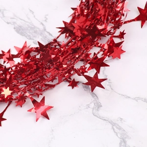 Detail of red metallic star tinsel garland for Christmas tree and party decorations