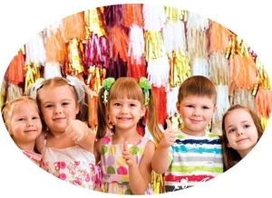Kids celebrating in front of a colorful foil fringe curtain for birthday party decor