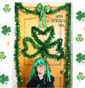 Detail of St. Patrick's Day green tinsel garland with shamrock pendants and party wig