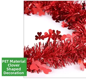 Close-up of shiny red PET festive garland with lucky shamrock clover leaf cutouts