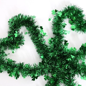 Green St. Patrick's Day tinsel garland with clover ornaments for festive party decoration