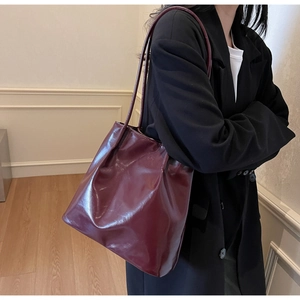 Detail of burgundy glossy leather tote bag showing large capacity and shiny finish