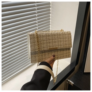 Detail of elegant tweed texture with gold metal buckle and luxury chain strap