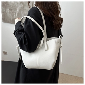 Détail du cabas en cuir blanc à motif litchi avec des nœuds élégants sur les côtés