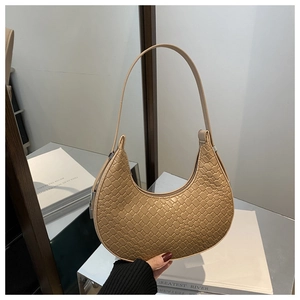 Détail du sac beige en forme de lune avec motif tissé texturé et boucle en métal argenté