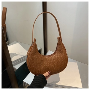 Détails macro d'un sac hobo en cuir tressé marron avec texture à damier et zip argenté