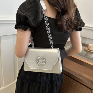 Silver metallic crossbody bag with crystal square buckle and chain strap shown on model