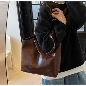 Detail of dark brown tote bag with high-gloss finish and spacious interior for women