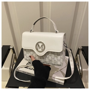 Détail du mini sac blanc avec imprimé monogramme M et logo en métal argenté brillant