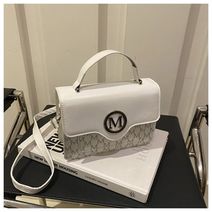 Détail du sac blanc avec motif M gris et boucle métallique ronde à logo sur le rabat