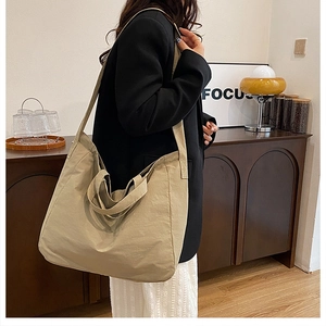 Detail view of khaki canvas tote bag showing wide shoulder strap and spacious interior