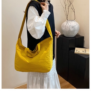 Detail of a large yellow minimalist tote bag with wide shoulder strap and handle