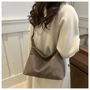 Borsa tote in camoscio marrone con tracolla regolabile indossata a spalla in autunno