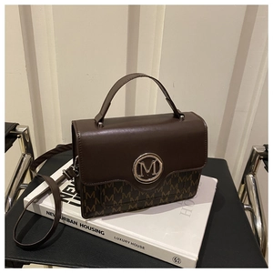 Détails du sac à main en cuir marron foncé avec logo M argenté et motif monogramme chic