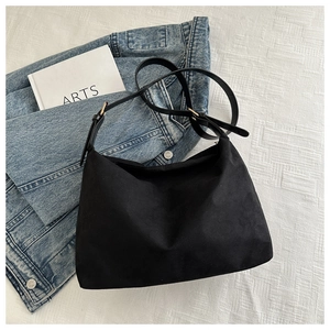 Dettaglio borsa hobo in tela nera con tracolla regolabile in pelle e fibbia dorata