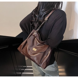 Détail du sac cabas en similicuir marron foncé avec fermoir doré et bandoulière chaîne