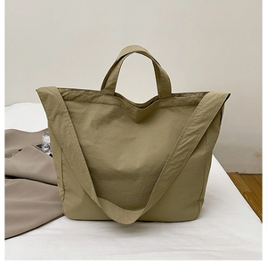 Detail of khaki tote bag with adjustable shoulder straps and durable nylon fabric texture