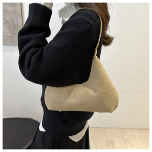 Side view of khaki faux suede shoulder bag with asymmetrical minimalist design on model