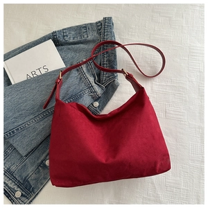 Dettaglio della grande borsa tote in pelle scamosciata rossa con tracolla regolabile