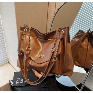 Détail du sac cabas caramel avec fermoir tournant métallique et bandoulière en chaîne