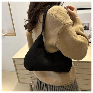 Detail of minimalist black suede hobo bag styled with a casual autumn sweater outfit