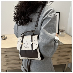 Polka dot pattern backpack with leather straps shown on model in home setting