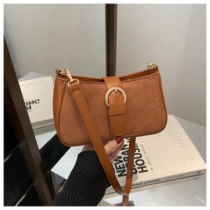 Detail of dark brown vintage underarm bag featuring suede texture and metal buckle