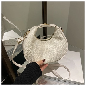 Detail of white half-moon bag with woven texture, golden hardware and top handle