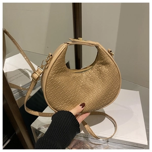 Detail of beige woven hobo bag with gold hardware and adjustable crossbody strap