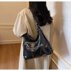 Détail de vue arrière d'un sac hobo en similicuir noir brillant avec design à double fermeture