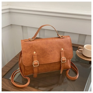 Gros plan sur le cuir PU marron rétro et la boucle métallique de la mallette vintage