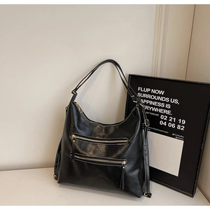 Détail d'un sac à bandoulière noir vintage avec surpiqûres blanches et double fermeture éclair