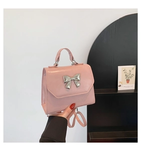 Détail du sac bandoulière rose clair avec un nœud métallique argenté poli et rabat