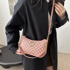 Sac à main rose vintage à monogramme avec logo M doré et bandoulière sur trench noir