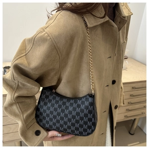 Detail of vintage black crescent bag with grey M-letter jacquard and gold chain strap