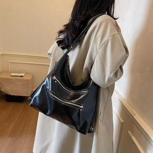 Sac bandoulière noir brillant vintage avec surpiqûres et deux poches zippées
