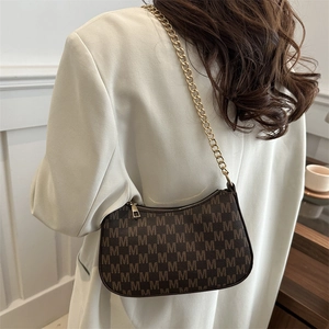 Retro brown monogram croissant bag with gold chain strap for women shown on shoulder