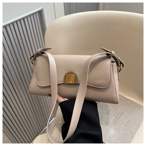 Detail of minimalist beige rectangle shoulder bag featuring a sleek gold crescent clasp