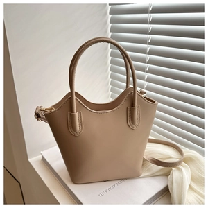 Detail of the unique wavy top edge and smooth texture of the beige bucket handbag