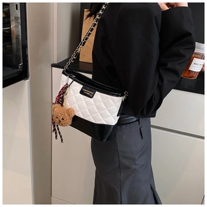Sac seau matelassé noir et blanc avec bandoulière chaîne et breloque petit ourson