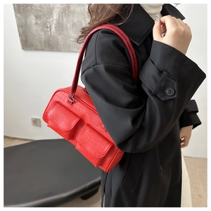 Detalle del bolso rojo de piel sintética de cocodrilo con dos bolsillos delanteros