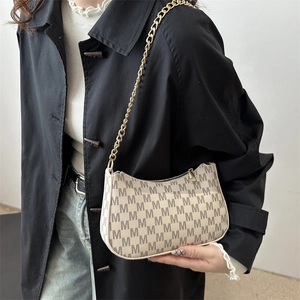 Retro crescent underarm bag with M-pattern and gold chain strap shown on model