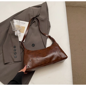 Dettaglio della borsa a spalla vintage marrone scuro con occhielli in metallo argento
