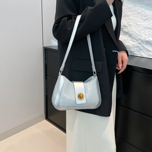 Silver sequin hobo shoulder bag with gold twist lock shown on model in professional outfit