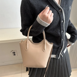 Minimalist apricot bucket bag with dual handles and shoulder strap for casual wear
