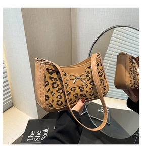 Detail of leopard print crescent bag with silver bow accent and faux leather trim
