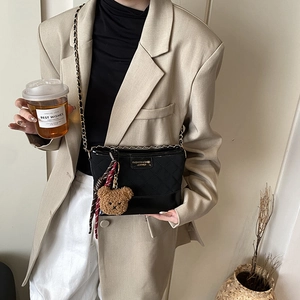 Sac seau matelassé noir avec bandoulière chaîne dorée et accessoires charmant d'ours