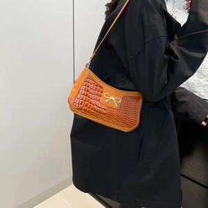 Minimalist brown crocodile-embossed crescent shoulder bag with golden butterfly buckle detail