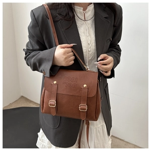 Detailed shot of brown vintage leather bag with gold buckles and lychee texture